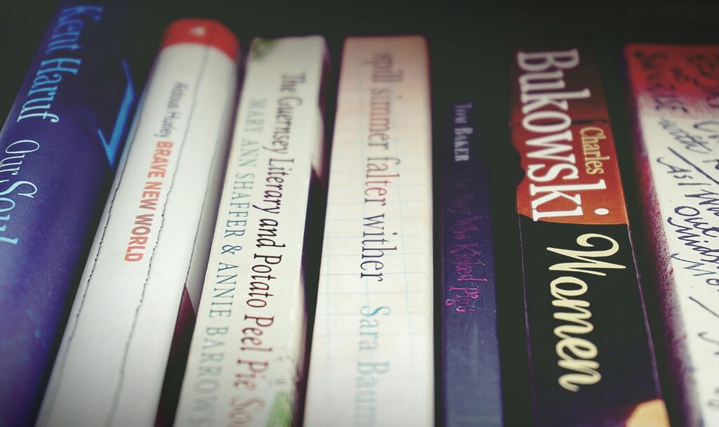 A close-up view of books on a shelf, showcasing various titles and authors.
